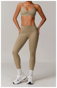 Detail of khaki high-waisted seamless yoga leggings paired with chunky white sneakers