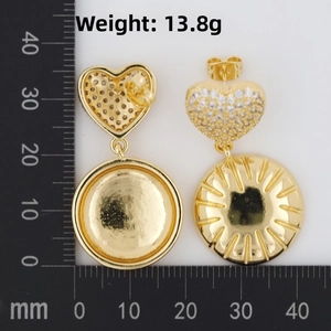 Detail view of heart-shaped gold drop earrings with diamond inlay and weight measurement