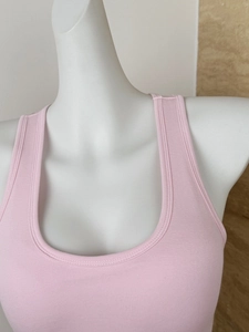 Detail of pink ribbed knit tank top showing U-neckline and stitching on mannequin