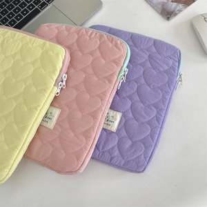 Detail of heart quilted laptop sleeve in pastel yellow pink and purple fabric colors