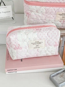 Detail of pink floral quilted cosmetic bags with heart texture and bow pattern