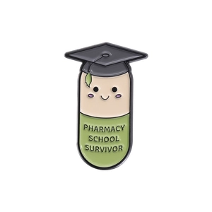 Macro view of graduation capsule enamel pin with Pharmacy School Survivor text