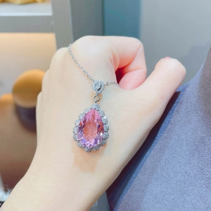 Close-up of a pear-cut pink morganite pendant necklace with a diamond halo setting