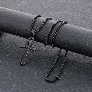 Macro view of polished black stainless steel Ankh cross pendant and box chain