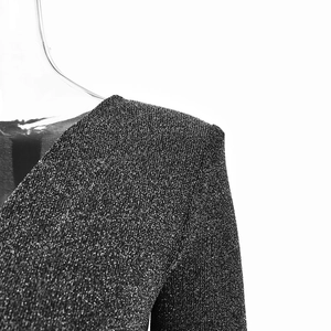 Détail du tissu à paillettes noires avec épaulettes sur un body sexy à col en V plongeant