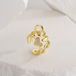Gold plated heart ring with Love lettering and zircon stones on a white stone block