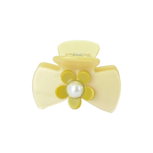 Detail of light yellow hair claw clip with an olive green flower and pearl embellishment