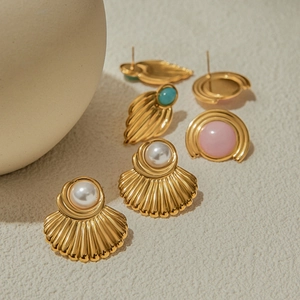 Close-up of vintage gold stud earrings with faux pearls and colorful gemstones