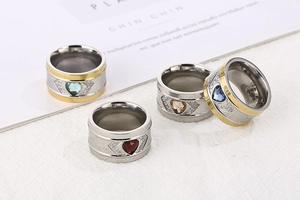 Macro shot of stainless steel wide rings featuring colorful heart-shaped crystals