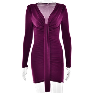 Détail de mini-robe violet foncé avec col en V, détail de nœud central et drapé froncé