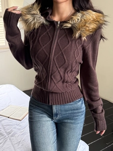Detail of dark brown cable knit sweater with faux fur trim hood and zip closure
