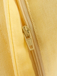 Macro detail of the yellow coarse-weave fabric texture and matching invisible zipper