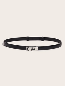 Detail of a thin black leather belt featuring a polished silver turn-lock metal buckle