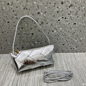 Macro shot of silver woven leather texture and knot detail on small square shoulder bag