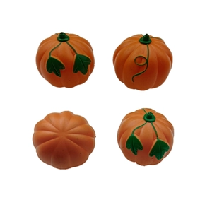 Set of four small orange artificial pumpkins with green leaves for Halloween decoration