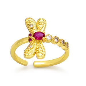 Detail of adjustable gold dragonfly ring with red gemstone and white crystal wings