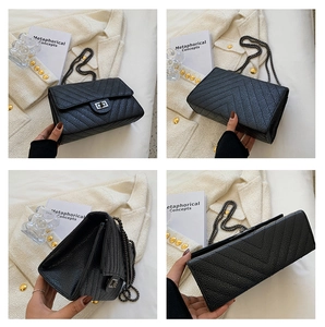 Close-up of black quilted small square bag with V-stitch pattern and silver swivel lock