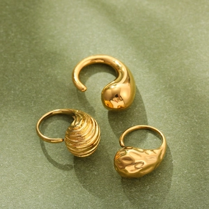 Detailed view of three gold textured rings featuring smooth, striped, and hammered finishes