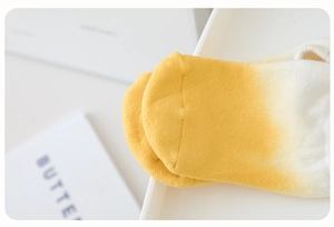 Detail of yellow gradient cotton yoga socks with reinforced stitching and knit texture