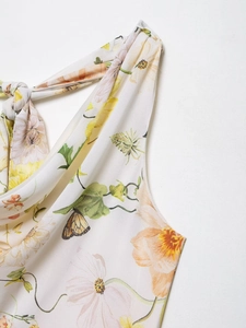 Detail eines Blumen-Chiffonkleids mit Neckholder-Bindung und sanftem floralem Muster
