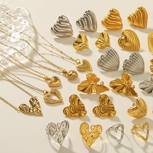 Detailed arrangement of gold and silver vintage lava heart necklaces, earrings, and rings