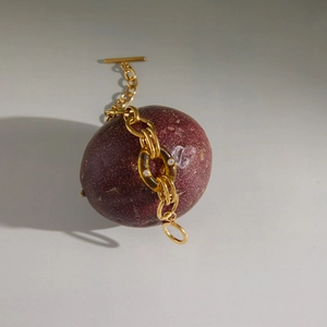 Detailansicht einer Goldkette mit Bernstein-Harzring und Kristalleinlagen und T-Verschluss