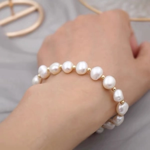 Baroque freshwater pearl bracelet with gold beads on wrist in natural light