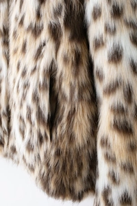 Close-up macro of stylish faux fur jacket featuring realistic leopard print texture