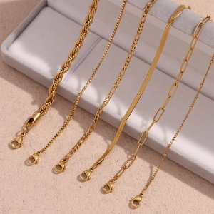 Detailed view of six 18K gold-plated Figaro and snake chain bracelets in a jewelry box