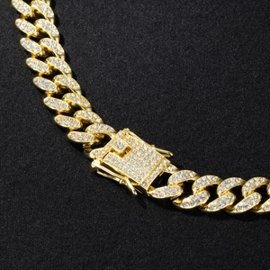 Close-up of gold Cuban link chain with pave-set rhinestones and secure square clasp