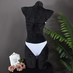 Rear view of a sexy white bikini with black trim and lace-up straps on a display mannequin