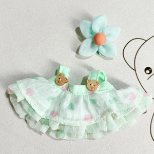 Flat lay of mint green tiered doll dress with pink hearts and bear buttons