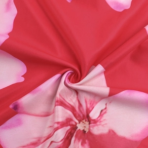 Detail of red floral print fabric with pink flowers and smooth draped texture