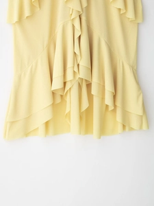 Detail of yellow halter top featuring tiered ruffle design and textured chiffon fabric