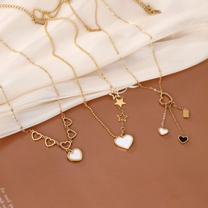 Elegant gold-plated stainless steel heart and star pendant necklaces on silk background