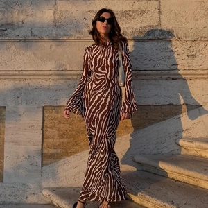Detail of flared cuffs and zebra print on long sleeve bohemian maxi dress in golden hour light