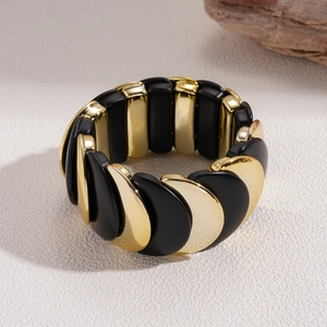 Dettaglio del bracciale elastico in acrilico con archi in metallo dorato e nero opaco
