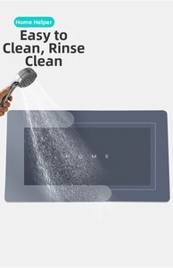 Deep blue non-slip bath mat with HOME text being rinsed by water for easy cleaning
