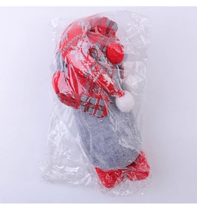 Détail de gnome de Noël avec bonnet en tricot rouge et corps en feutre sous emballage