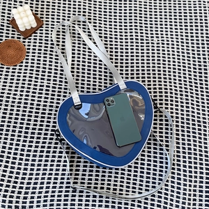 Detailed interior view of a blue heart-shaped Ita bag showing capacity for a smartphone