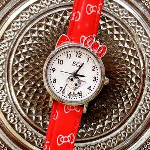 Close-up of a red cartoon cat quartz watch with a bow-shaped metal case for girls