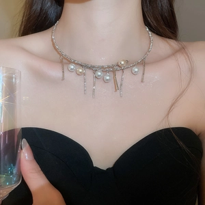 Detailed view of pearl tassel choker with metallic fringe on a model's neck for gala event