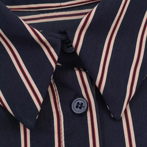 Macro view of navy shirt collar with red and beige stripes and resin buttons