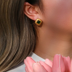 Detail showing vintage gold-plated square green zircon stud earring worn on model ear