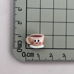 Detailed macro view of a pink resin cup accessory with size scale for DIY crafts