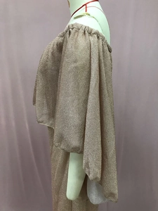 Detail van ruffelmouw en glinsterende goudkleurige stof op de off-shoulder avondjurk