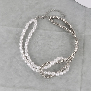 Detail of silver beads and white imitation pearl strands with lobster clasp and chain