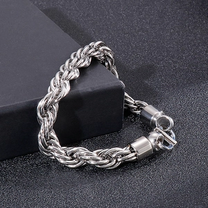 Vue macro d'un bracelet gourmette punk en acier argenté sur support noir élégant