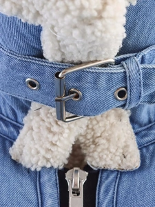 Detail of light blue denim jacket with fleece collar, metal buckle belt and zipper