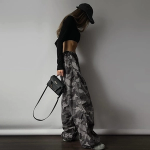 Vista dettagliata dei pantaloni cargo mimetici grigi con borsa a tracolla streetwear